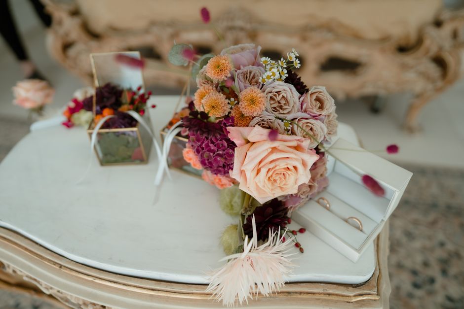 wedding rings and bouquet on table