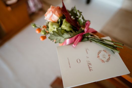 Close-up of a wedding program with a floral bouquet beside it, capturing elegant wedding decor.