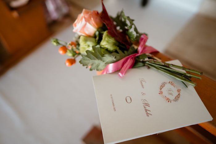 Wedding program beside a floral arrangement