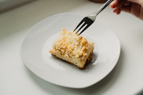 Free Close-up of a piece of streuselkuchen on a white plate with a fork poised to take a bite. Stock Photo