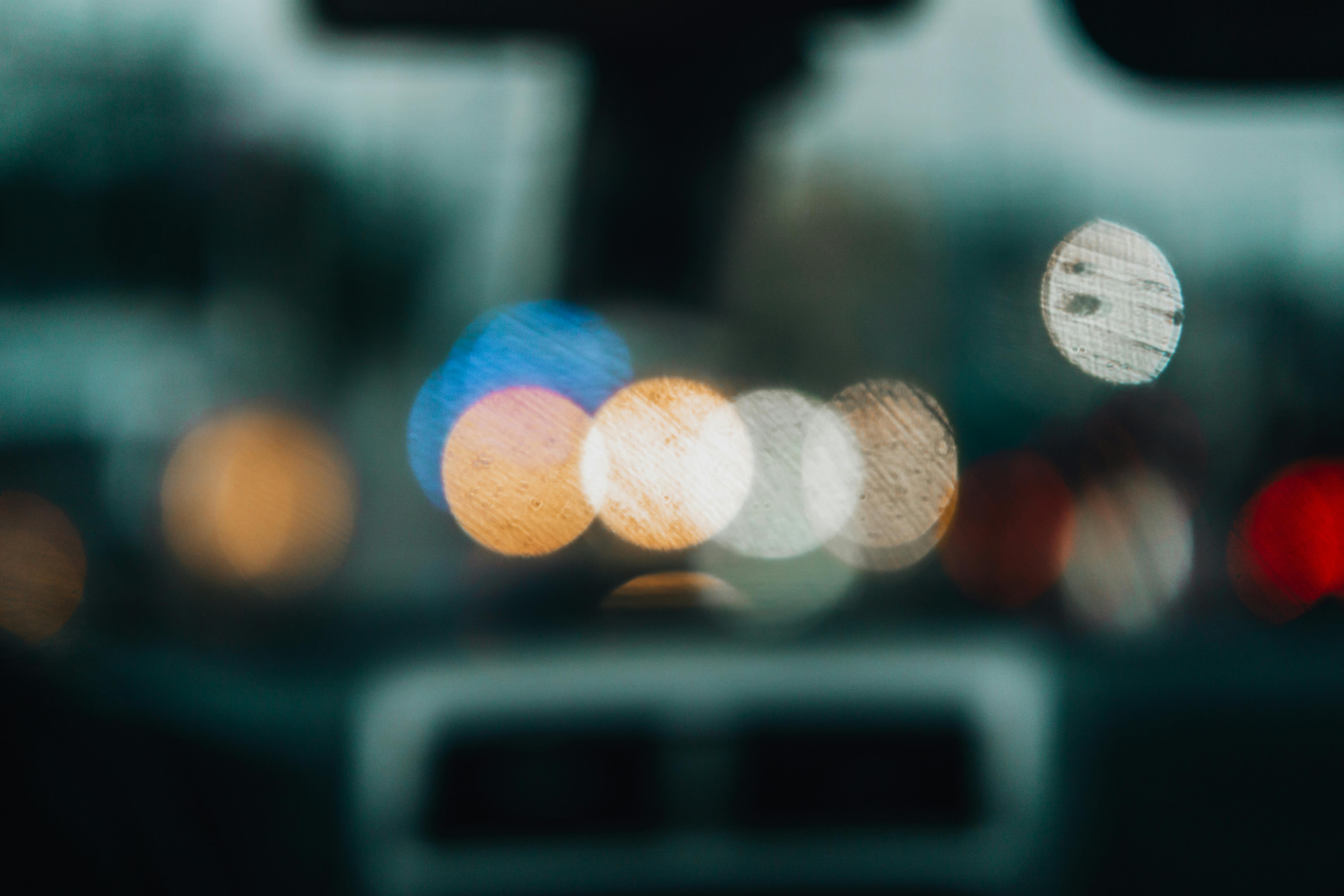 Blurred city lights through a rainy car window creating a bokeh effect.