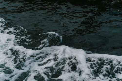 Free Vivid capture of ocean waves and foamy surf in motion. Ideal for themes of nature and energy. Stock Photo