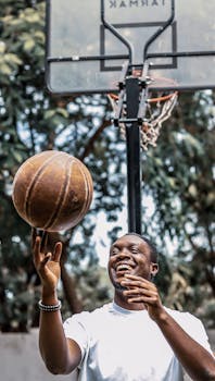 A young man enjoying playing basketball on a sunny day in Accra, Ghana.