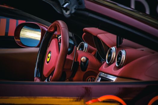 Close-up of a luxury sports car interior showcasing red leather seats and steering., free online jigsaw puzzle on JigsawPuzzlesFreeOnline.org