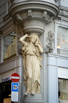 Detailed sculpture on a building corner in central Vienna, showcasing classic European architecture.