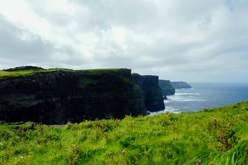 Free Stunning landscape of the Cliffs of Moher with lush greenery and ocean views. Stock Photo
