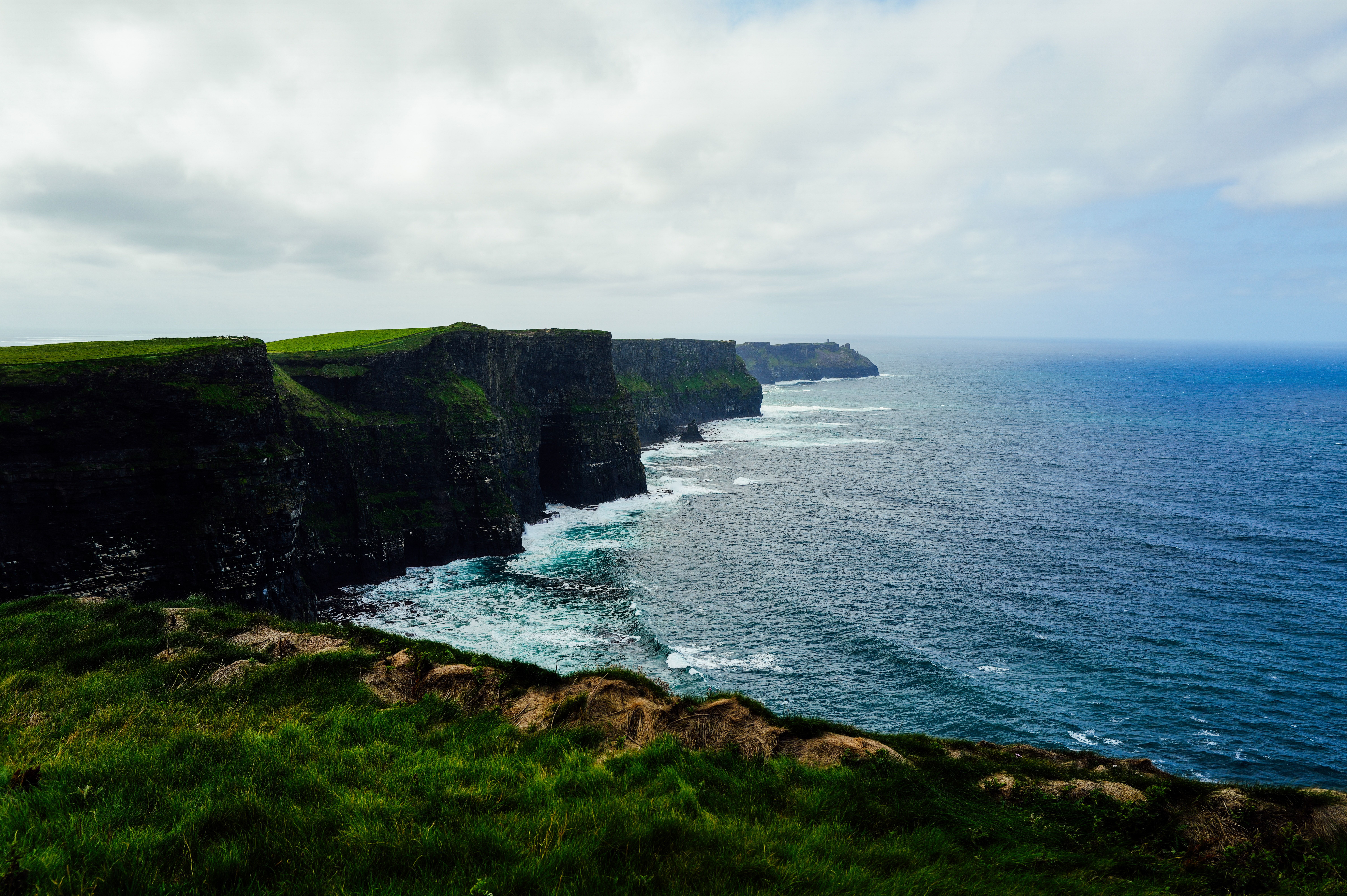 A moody, misty photo of the Cliffs of Moher, Ireland, evoking the <em class=