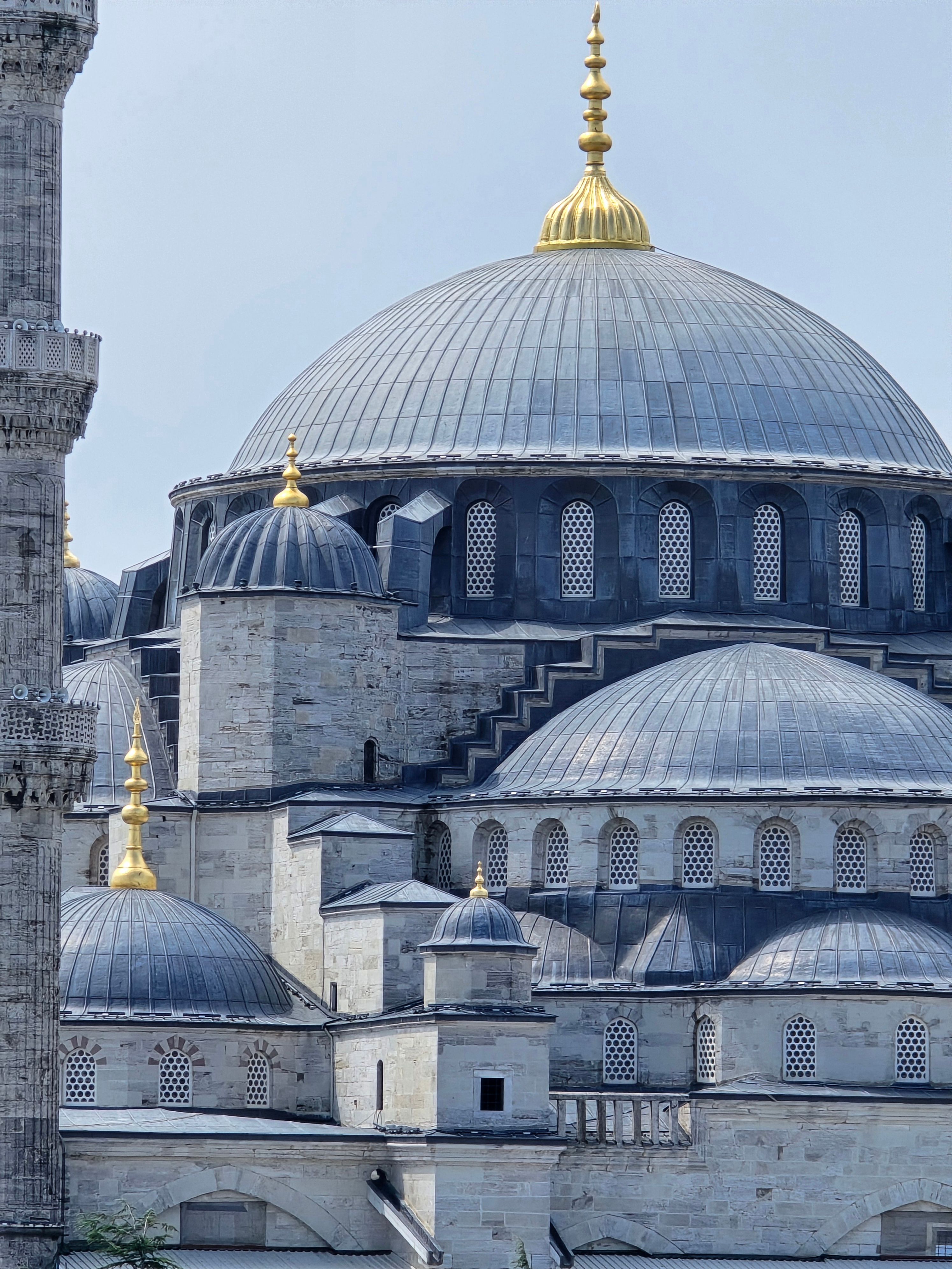 Close-up view of the Blue Mosque's stunning domes in İstanbul, showcasing Ottoman architecture.