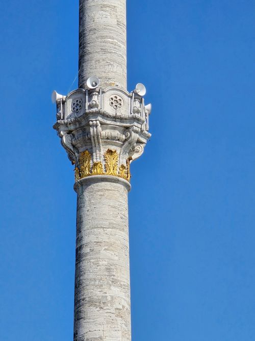 Free Close-up of an ornate minaret's architectural details set against a clear blue sky in Türkiye. Stock Photo