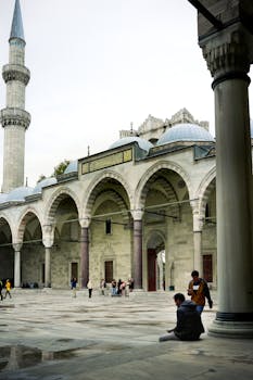 人们在土耳其伊斯坦布尔的苏莱曼尼耶清真寺庭院里行走