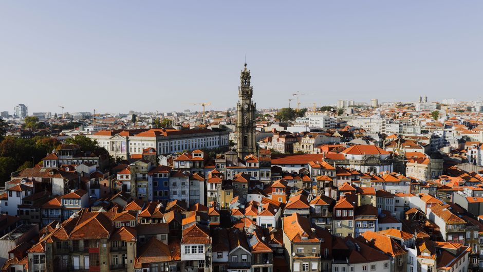 A beautiful aerial view of Porto, Portugal, highlighting the iconic Clerigos Tower at sunset.