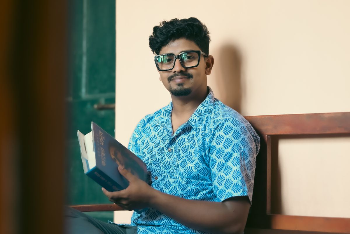 Man wearing glasses reading a book at home