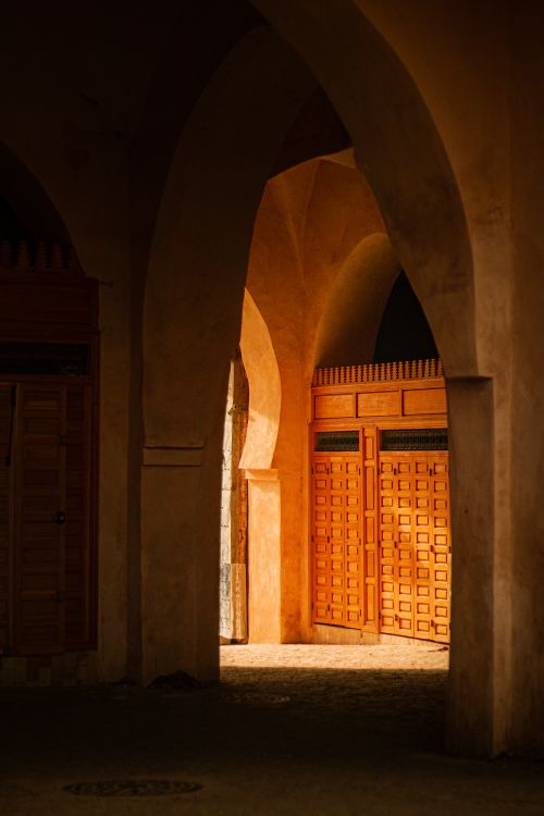 Free A beautiful view of historic arched doorways illuminated by warm sunset light. Stock Photo