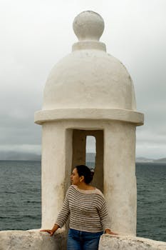 站在里约福塔莱萨圣克鲁斯的女人，观察海洋风光