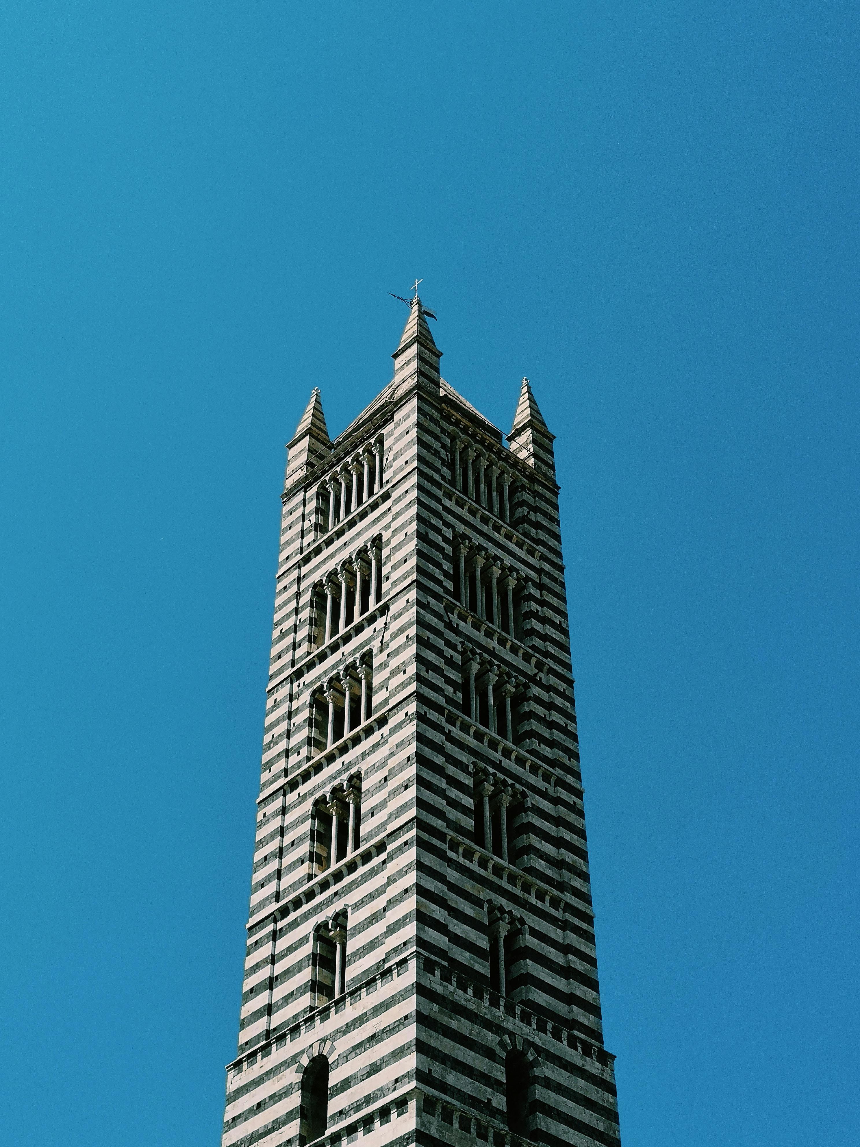 在充满活力的蓝天下，意大利托斯卡纳锡耶纳大教堂塔呈现出美丽的低视角