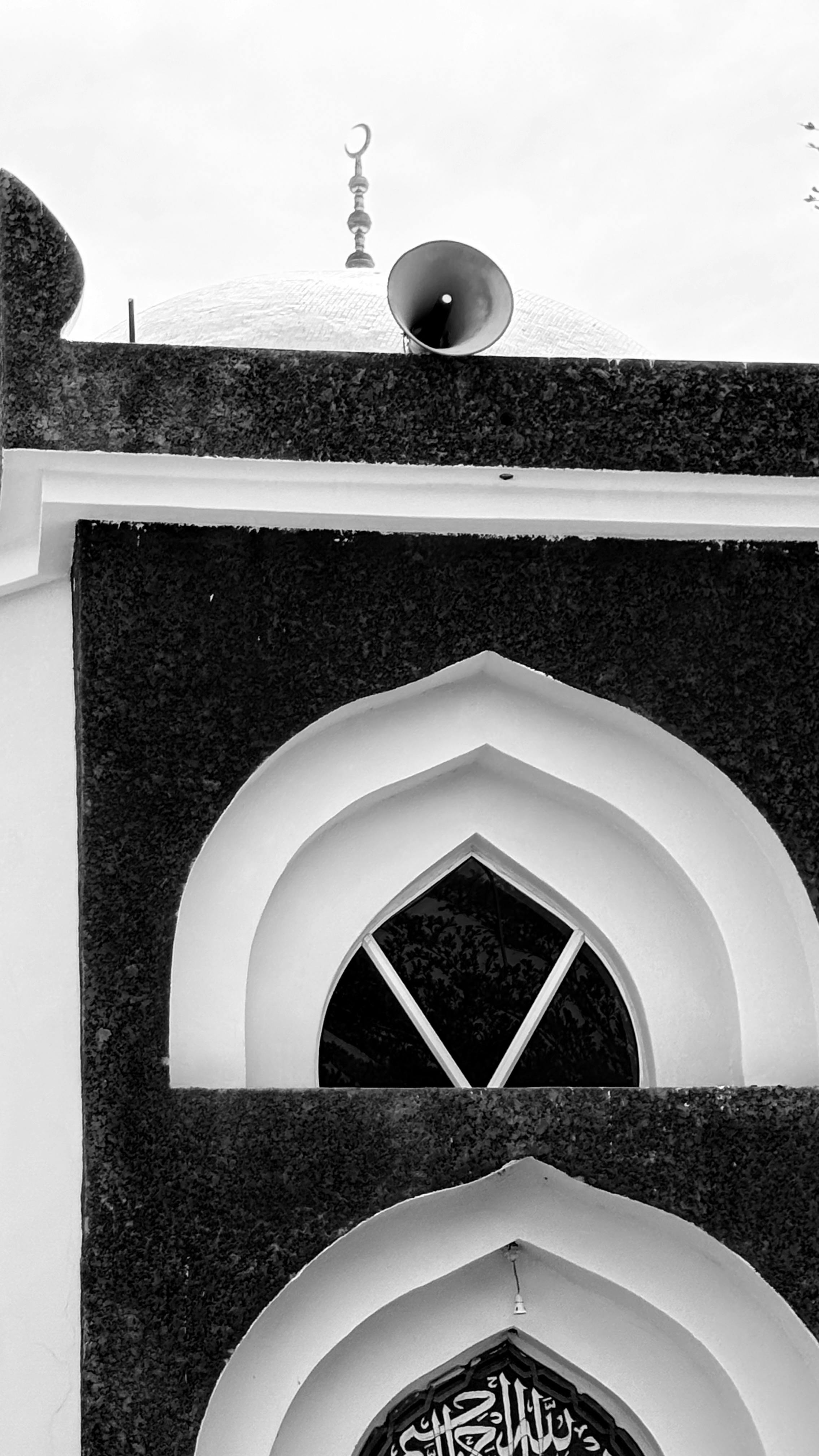 Gratuit Photographie en noir et blanc de la façade d'une mosquée avec des motifs géométriques et un dôme. Photos