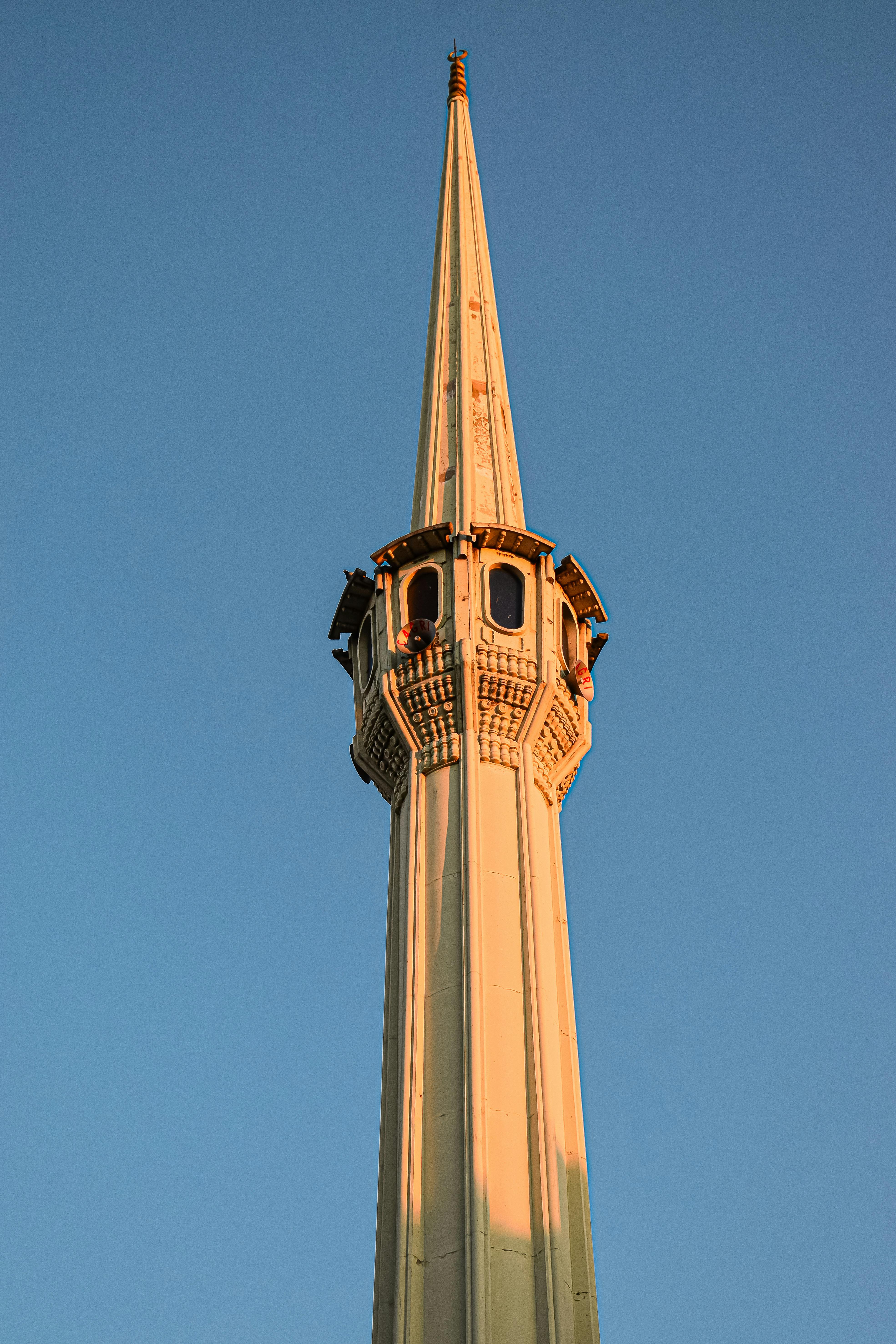 一座美丽的尖塔，在晴朗的天空中伫立，展现了伊斯兰建筑的精致细节