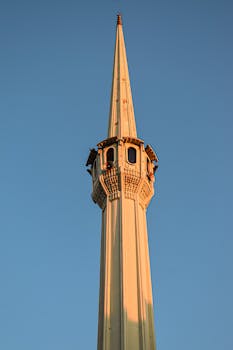 一座美丽的尖塔，在晴朗的天空中伫立，展现了伊斯兰建筑的精致细节