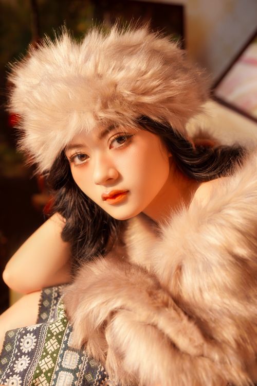 Free Elegant woman in fur clothing posing indoors with soft lighting. Stock Photo