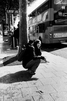 Black and white street scene in Dublin featuring a bus and a person crouching.