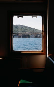 通过船舱的窗户，可以欣赏到海洋和远处山丘的宁静景色