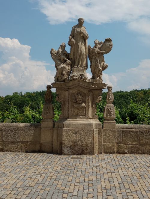 Free Stone statue of St. John of Nepomuk with angels on Charles Bridge in Kutná Hora. Stock Photo