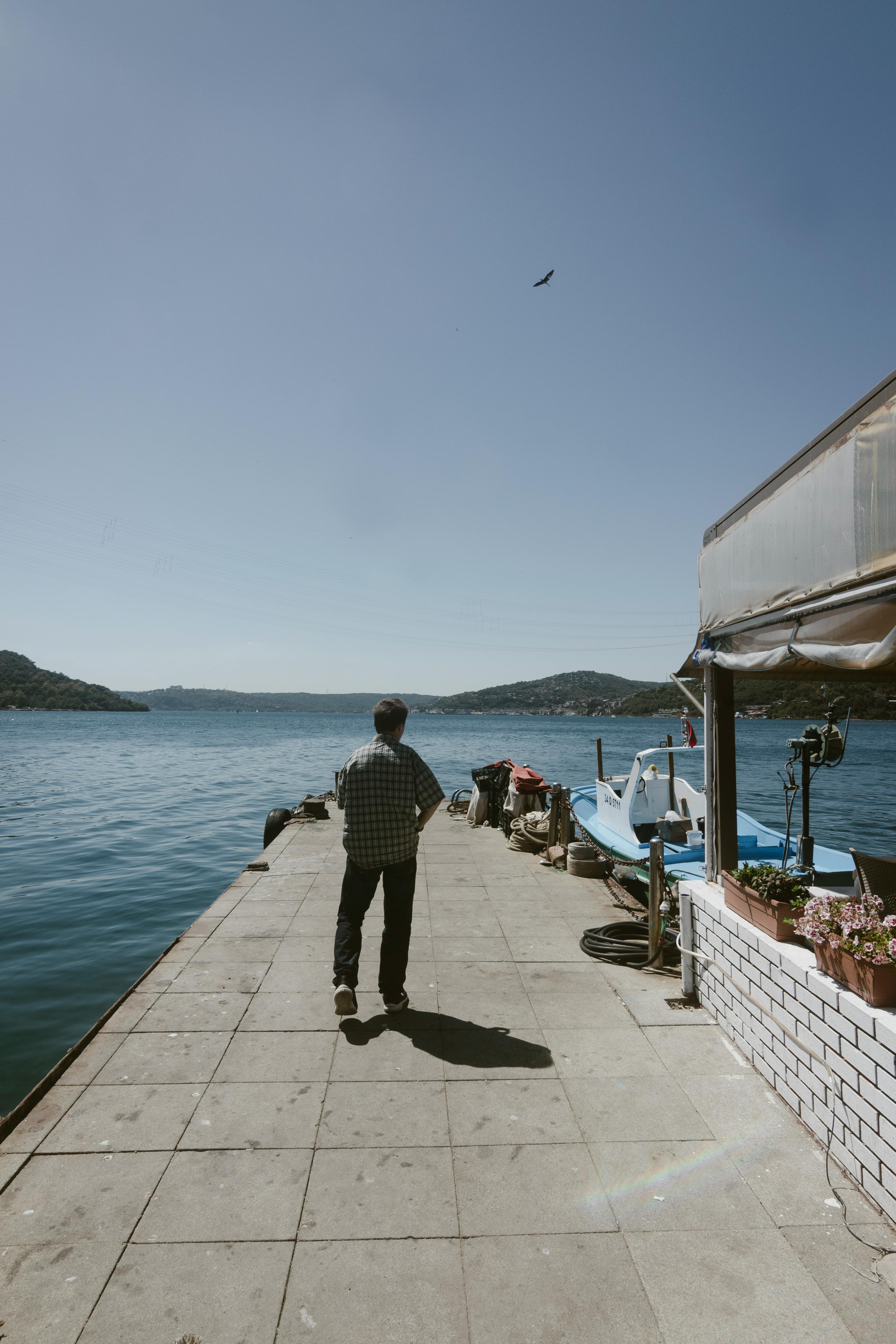 在阳光明媚的伊斯坦布尔码头，一名男子平静地散步