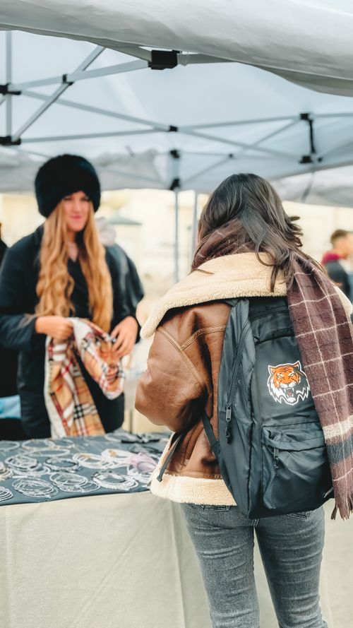 Free Two women interacting at outdoor market stall during winter with cozy attire. Stock Photo