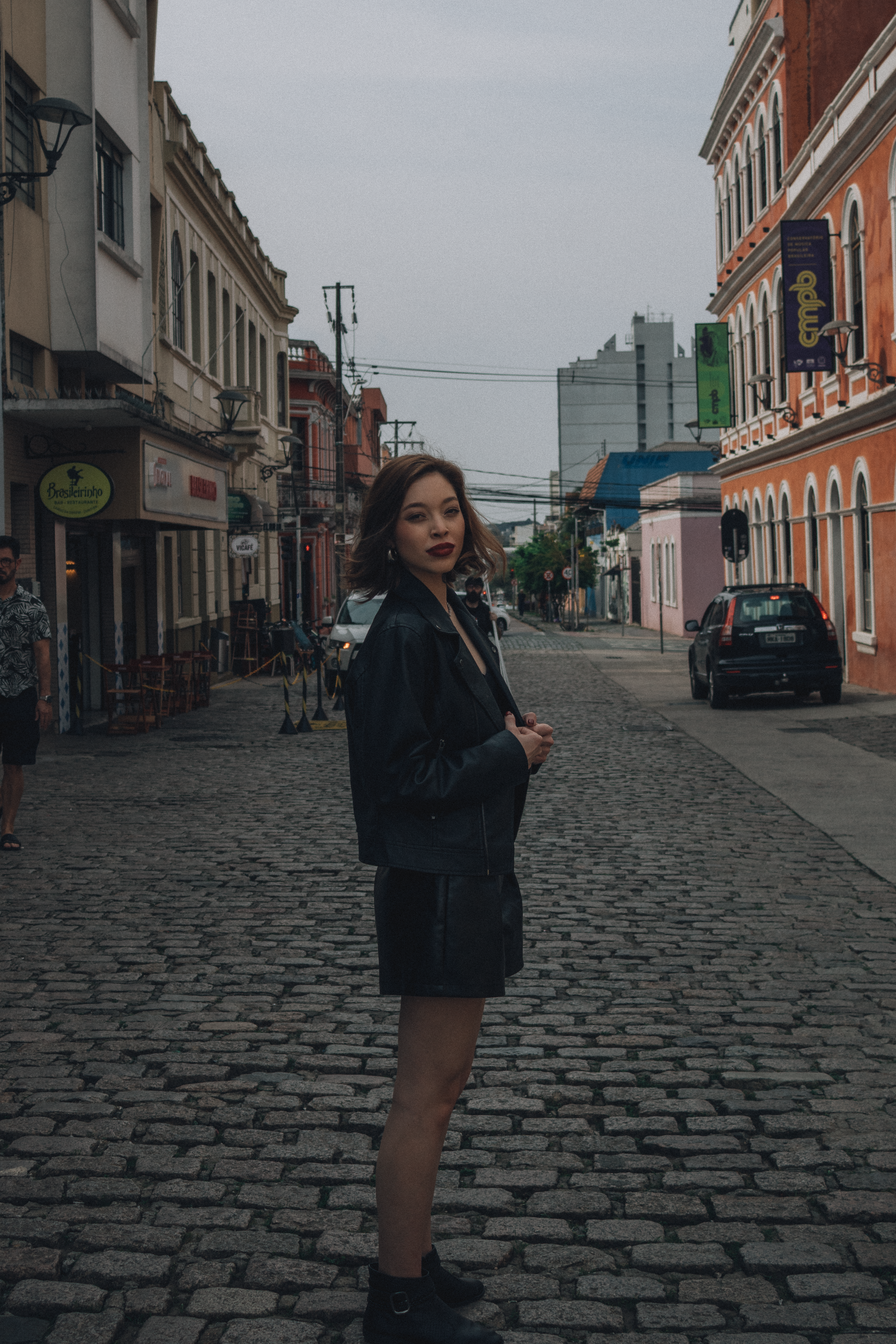 Young Woman in Black Outfit on Cobblestone Street · Free Stock Photo