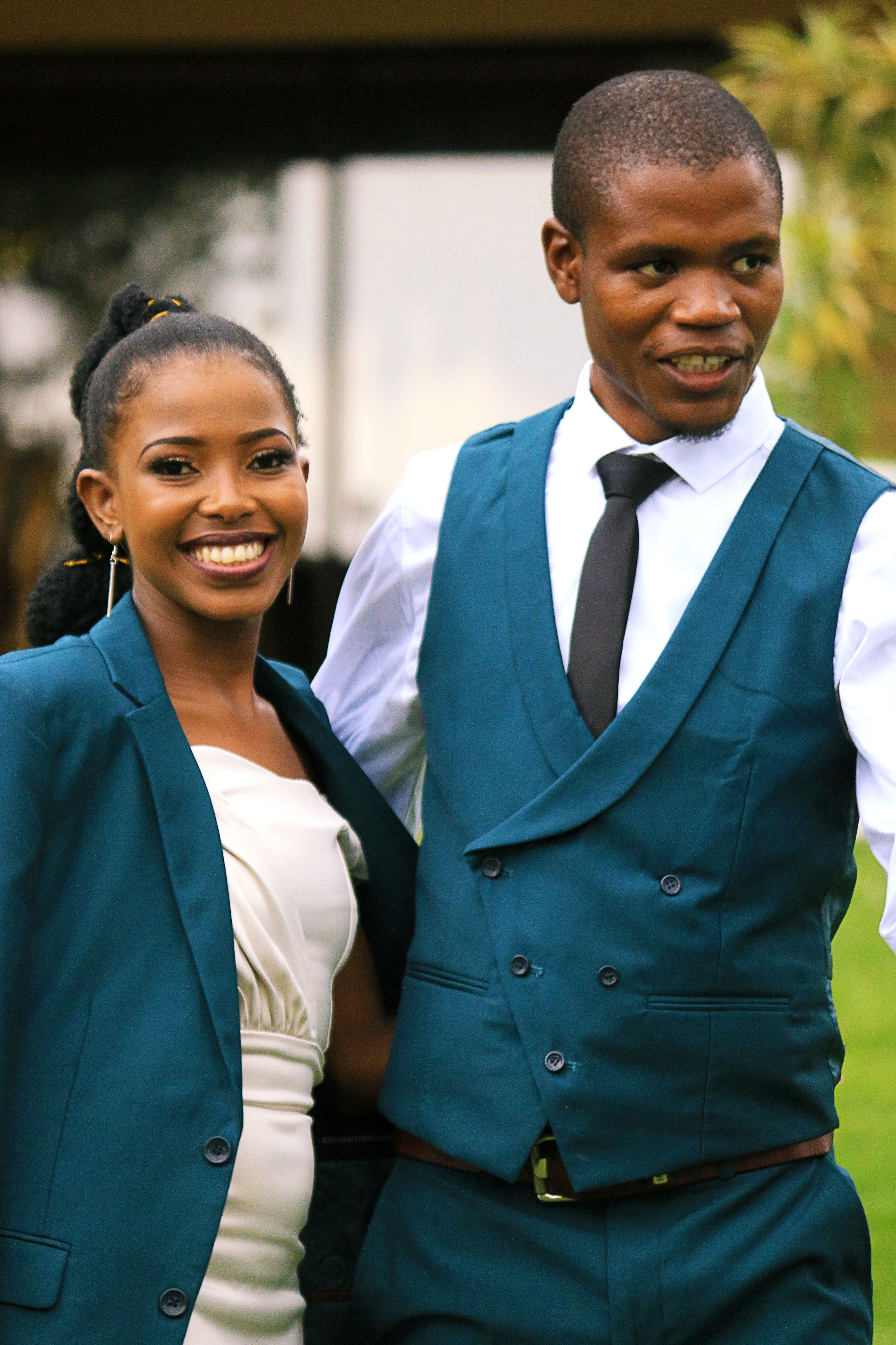 Happy couple in coordinated blue formal outfits enjoying a day outdoors.