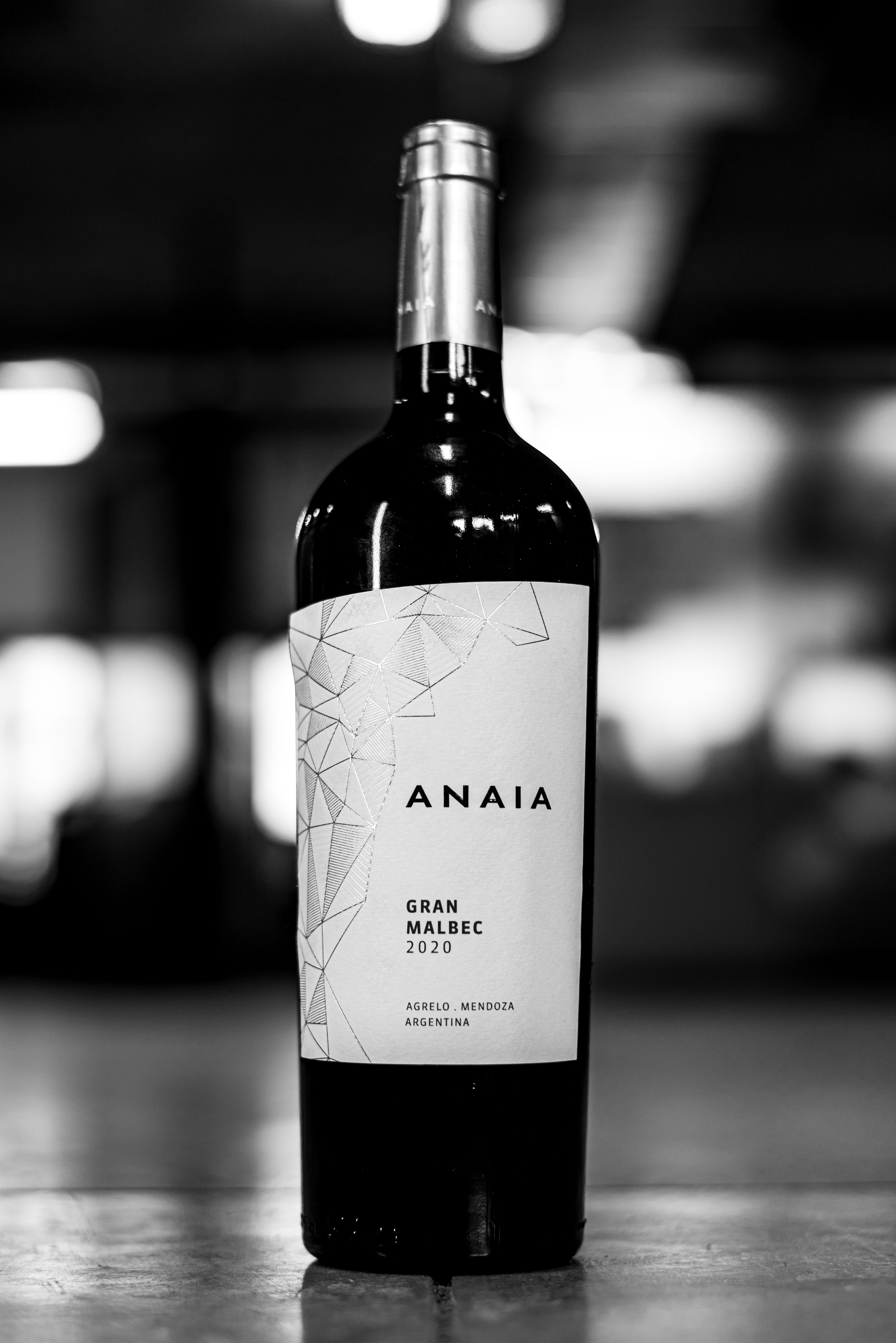 A classic black and white image showcasing a bottle of Anaia Gran Malbec 2020 wine.