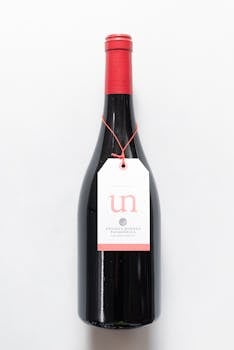 Classic red wine bottle with label on a minimalist white background, perfect for product photography.
