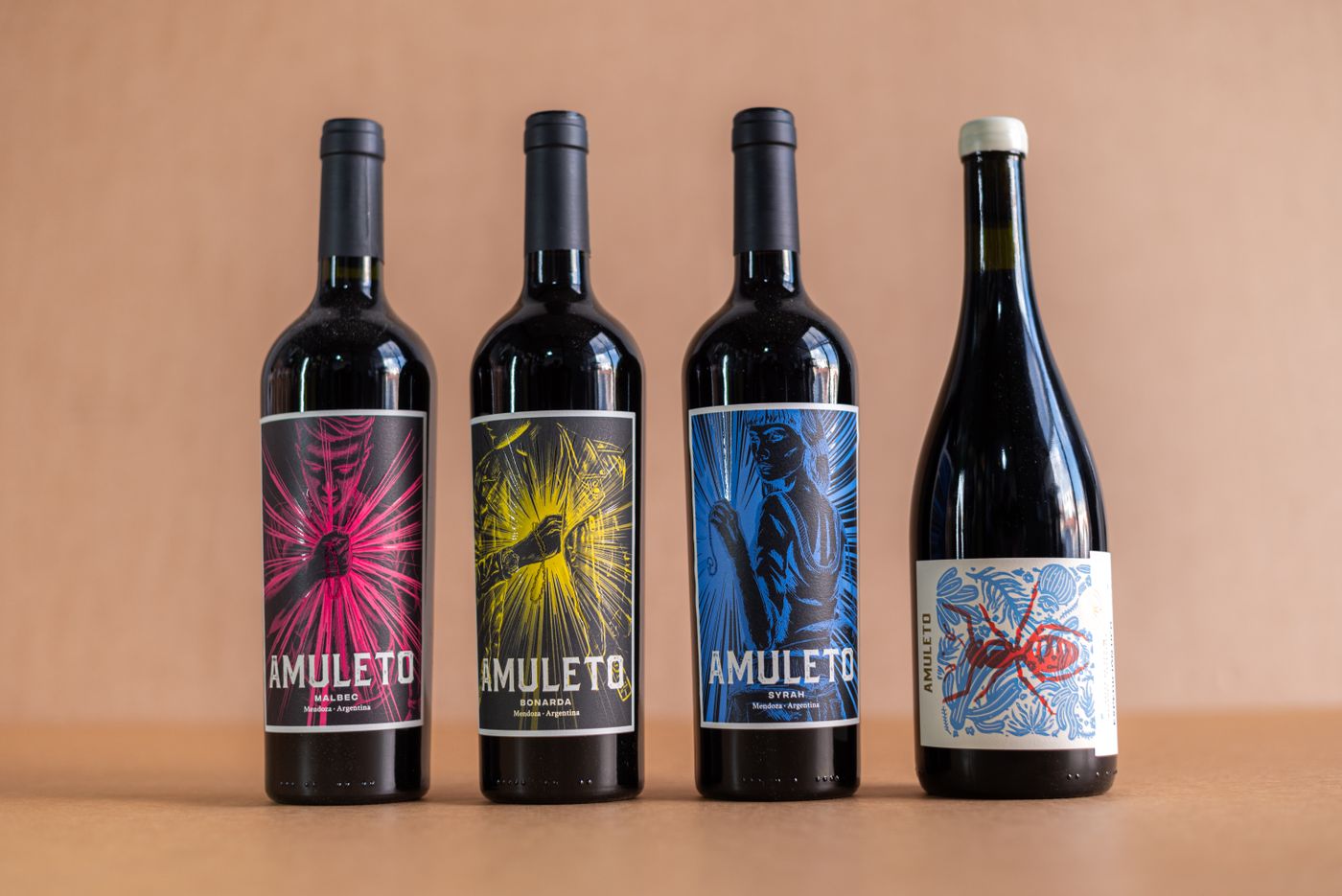 Four exquisite wine bottles with vibrant artistic labels on a minimalist background, perfect for a winery product showcase.