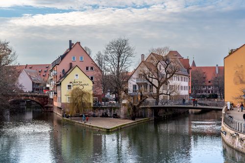 Free Charming riverfront view of historic Nuremberg architecture with serene waters and winter ambiance. Stock Photo