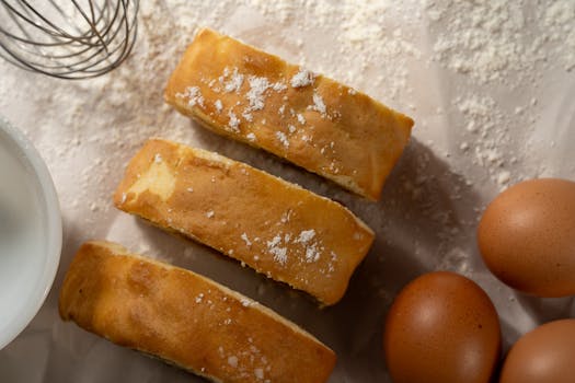 Close-up of fresh cake slices with eggs and flour, perfect for baking themes.