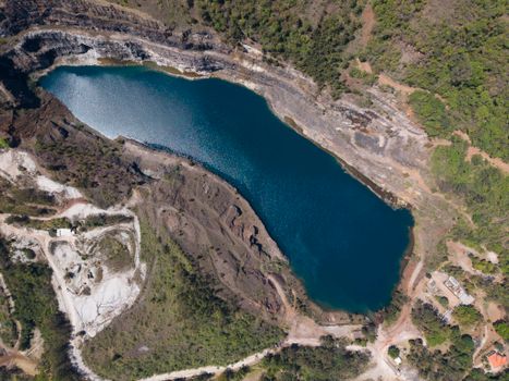 A breathtaking aerial view of a crystal-clear lagoon surrounded by lush greenery and rugged terrain in Belo Horizonte, Brazil.