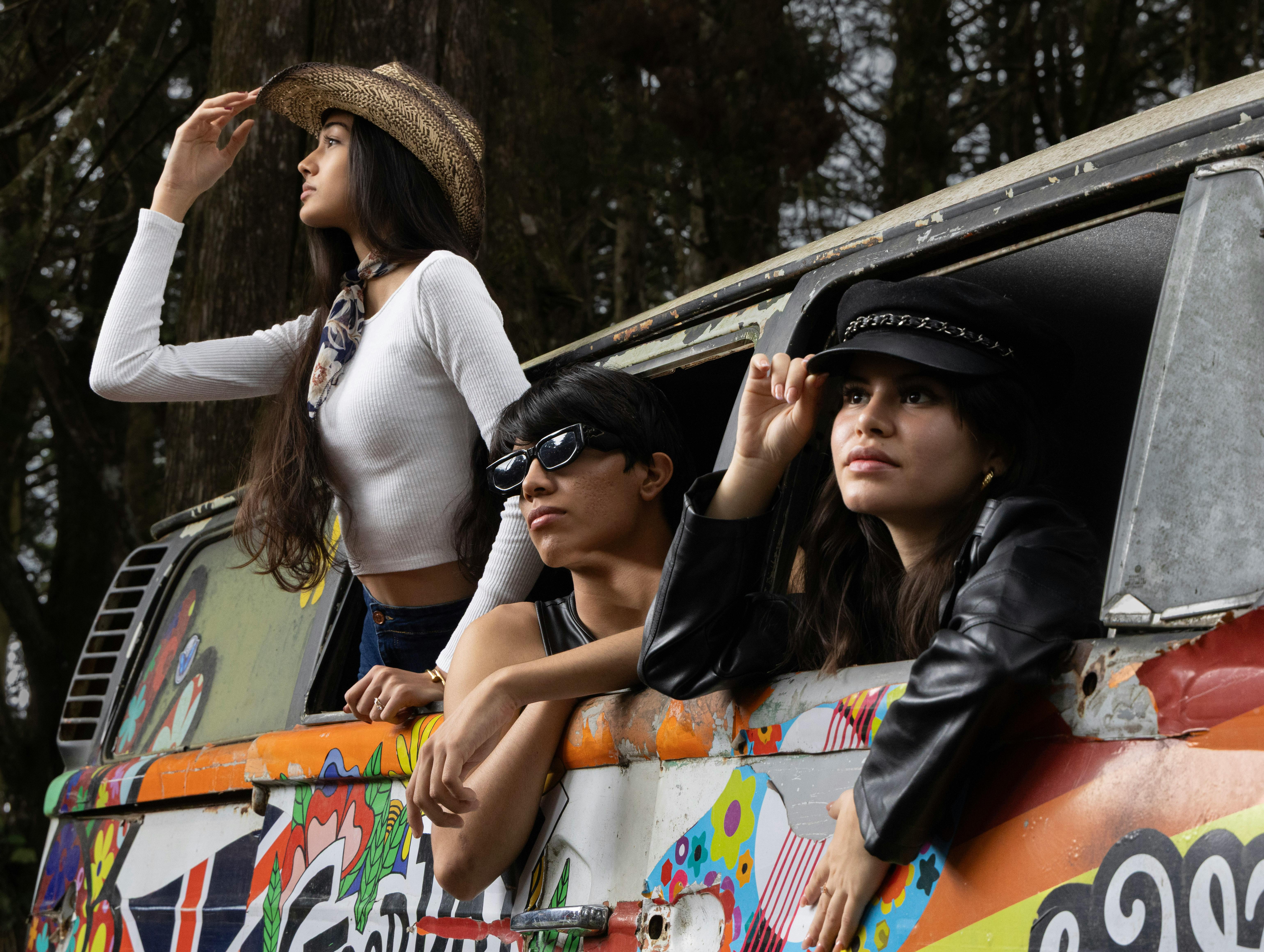 grátis Três amigos exploram a floresta na Província de Alajuela, Costa Rica, posando com uma van coberta de grafite. Foto profissional