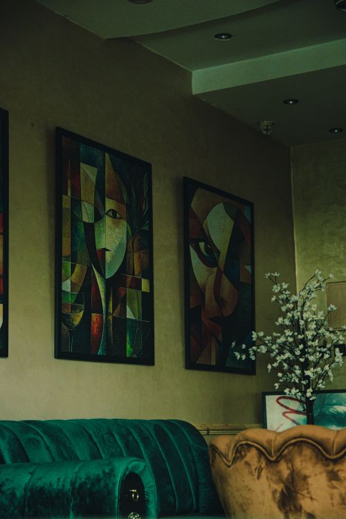 Free Charming Meknes cafe interior with abstract paintings, artistic vibe, vintage seating, and floral decor. Stock Photo