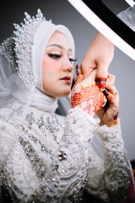 A beautiful Muslim bride in Aceh, Indonesia adorned with detailed henna and sparkling attire.