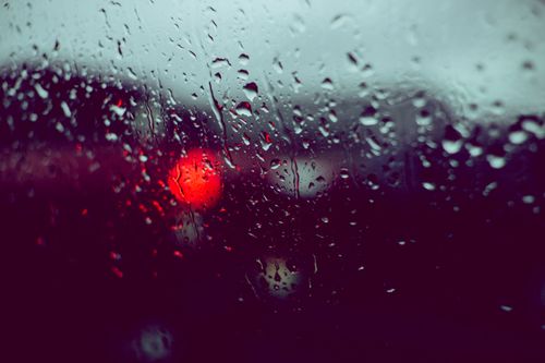 Free Artistic capture of raindrops on a car window with blurred city lights at night. Stock Photo