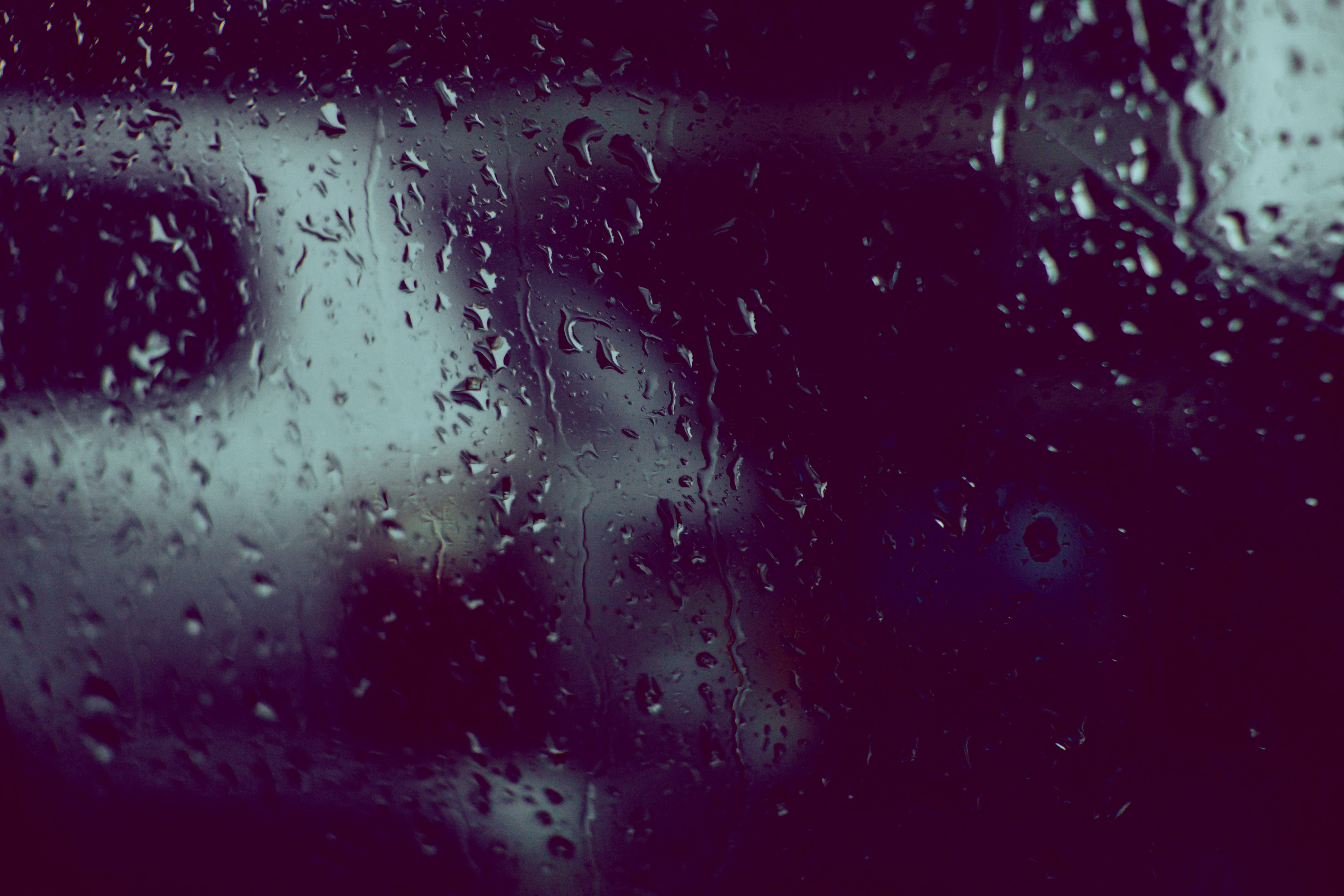 Rain-streaked window looking out over the Oracle riverside terrace on a grey afternoon