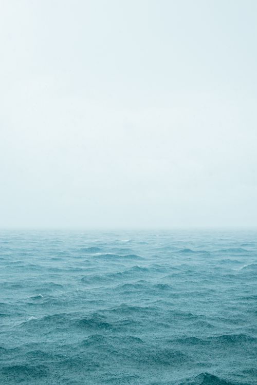 Free A calming view of ocean waves and an overcast sky, evoking serenity and peace. Stock Photo