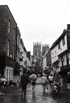 Black and white photograph of a bustling street leading to the iconic York Minster in York, England.