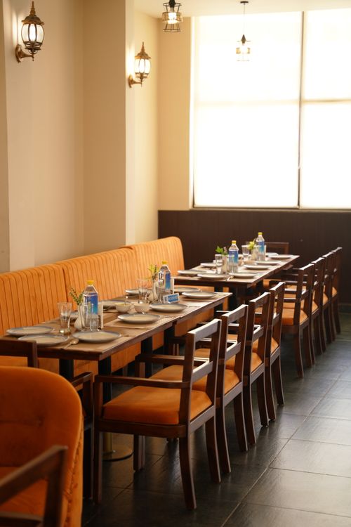Free Stylish indoor restaurant seating with elegant table settings and natural light. Stock Photo