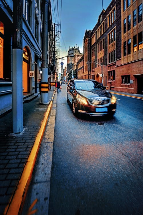 Free stock photo of black car, busy street, old building