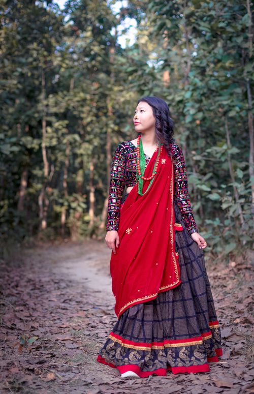 Free Woman in Nepalese attire walking on a forest path, showcasing cultural fashion. Stock Photo