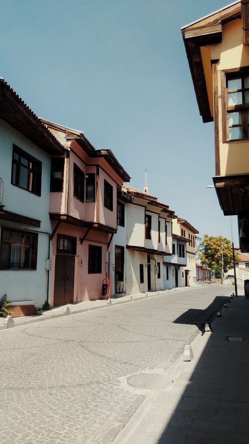 Free A picturesque street in Uşak, Türkiye, featuring colorful traditional houses on a sunny day. Stock Photo