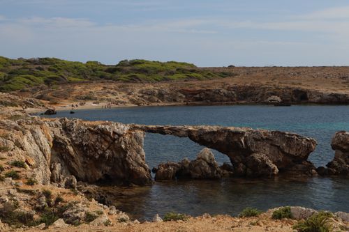 Free Breathtaking view of a natural stone bridge over clear waters on the coastline of Sicilia, Italy. Stock Photo