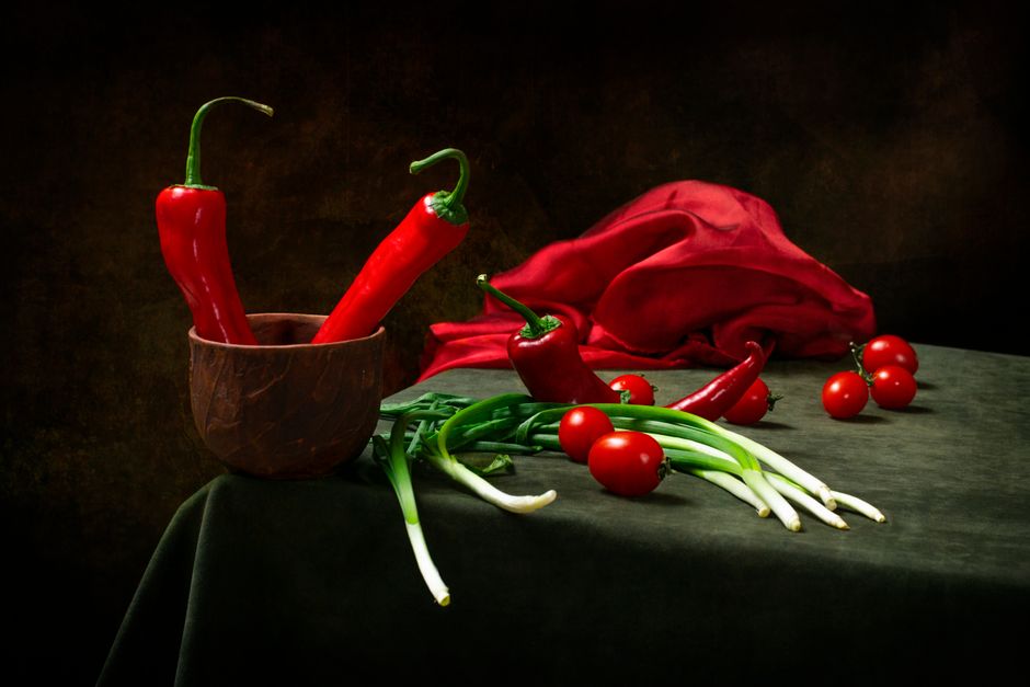 Still life com pimentões vermelhos, tomates cereja e cebolinhas.