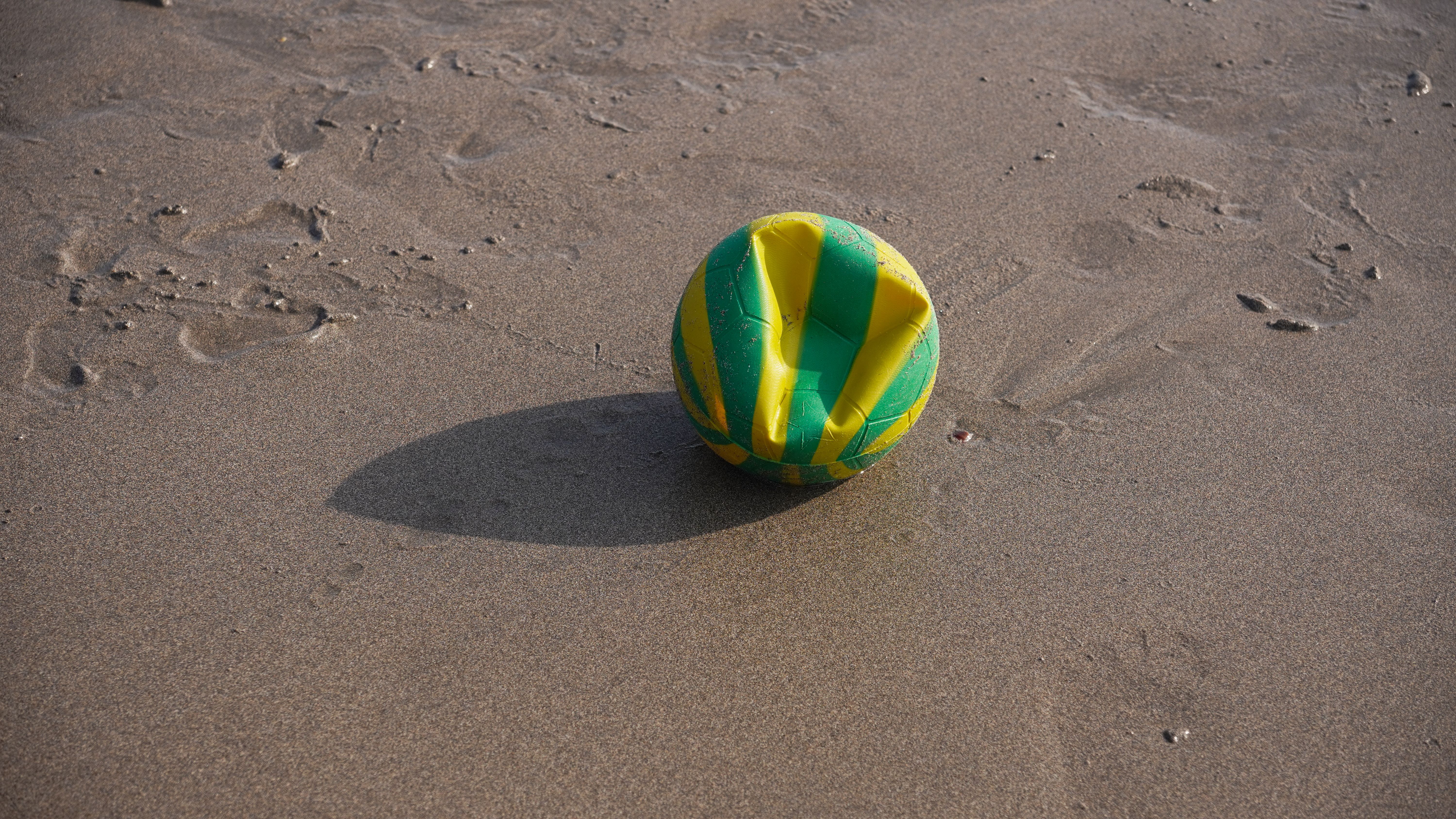 Deflated Green and Yellow Ball on Beach Sand · Free Stock Photo